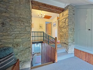 A stone wall, wooden staircase, and a door.