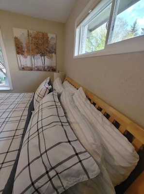A bedroom with a bed, a window, and a painting on the wall. - Hot tub, Shuffleboard, Full kitchen, Serene, Forest View/Hiking, 1 King, 1 Queen (Shelton)