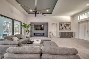 Relax in this stylish living room with a flat-screen TV, fireplace, and comfortable grey sofa.