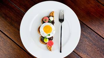 A white plate with a breakfast dish on a wooden table.