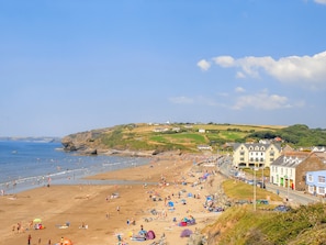 Une plage où l’on voit des gens, des tentes et des bâtiments le long du rivage.