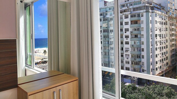 A room with a view of a beach and high-rise buildings. - Rio Spot Homes C056 (Rio de Janeiro)