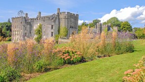A castle with a large lawn and garden in front. - Druidston Old Farmhouse (Druidston Haven)