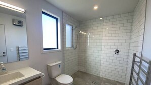 A bathroom with a toilet, sink, and shower area.
