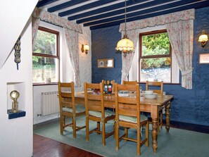 A dining room with a wooden table, chairs, and a chandelier.