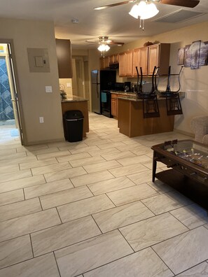 A spacious kitchen with wooden cabinets, a central island, and a ceiling fan.