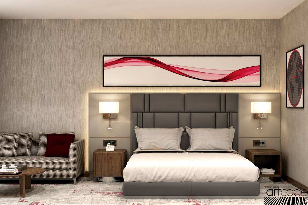 Ein modernes Hotelzimmer mit einem großen Bett, einer Couch, zwei Nachttischen und einem an der Wand befestigten abstrakten Kunstwerk.