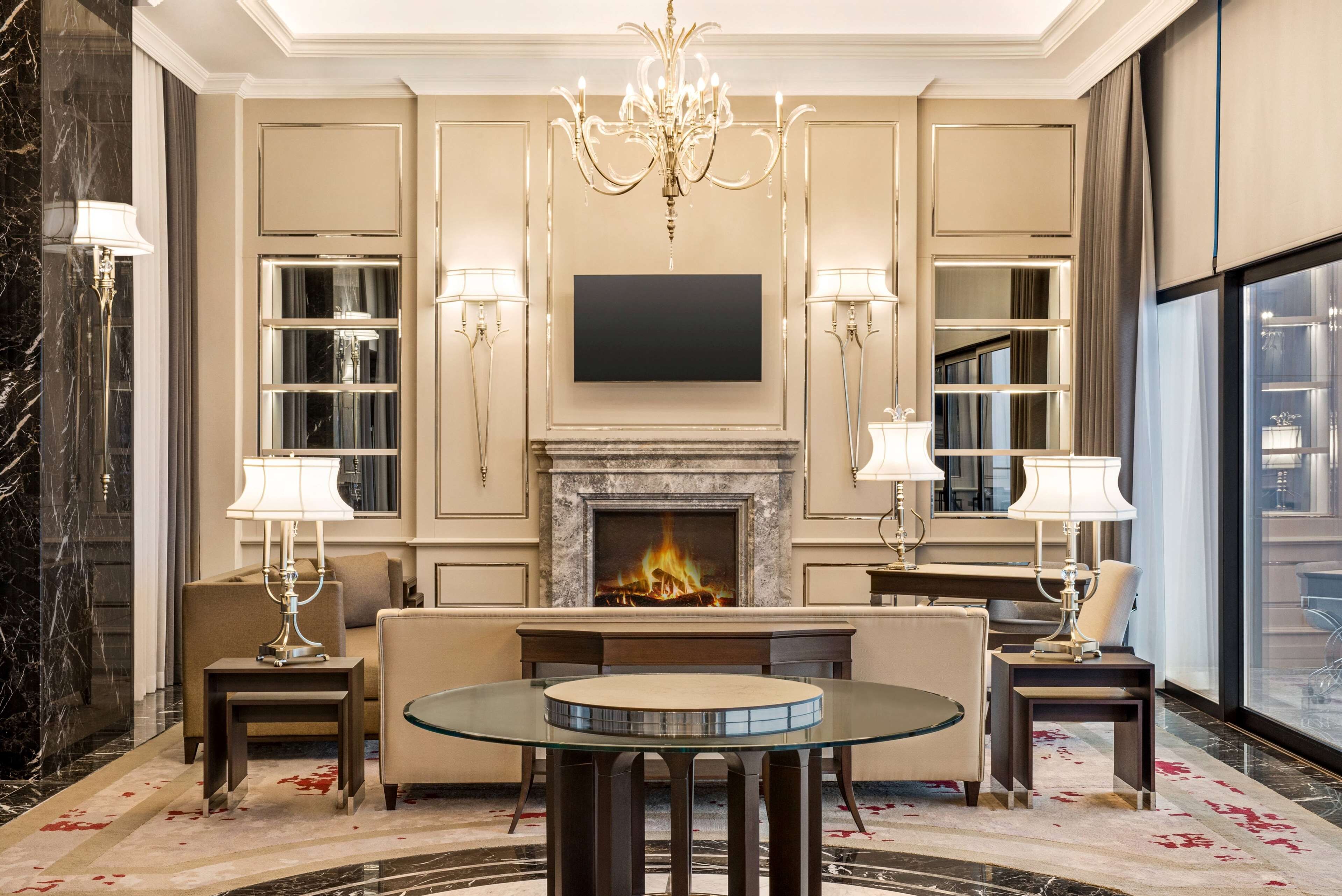 Un salon luxueux doté d’une cheminée, d’un téléviseur à écran plat et d’un mobilier élégant.