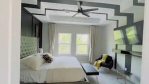 A modern bedroom with a bed, bedside table, and a ceiling fan. - Gray Lux Hse 3BR|3.5Bath~Downtown|MedCenter|HotTub (Houston)
