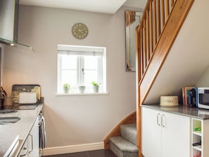 A kitchen with a window, a clock, and a staircase. - 1 bedroom accommodation in Richards Castle, near Ludlow (Richards Castle, near Ludlow)