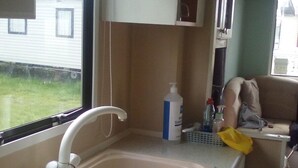 A compact kitchenette with a sink, a faucet, and a small countertop. - River Views Dog Friendly Caravan 3 Bedrooms (Rye)