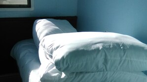 A bed with white bedding and a package of Airmax topper pillows. - River Views Dog Friendly Caravan 3 Bedrooms (Rye)