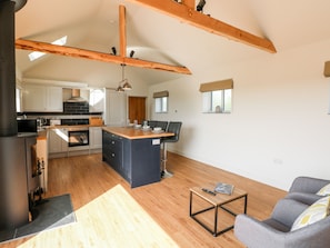 Una cocina amplia con vigas de madera, una isla central y electrodomésticos modernos.