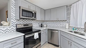 A modern kitchen with grey cabinets, a microwave, stove, oven, dishwasher, and a sink. - Waterfront *Extended Stay Discount* Pet Friendly (Myrtle Beach)
