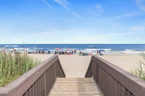 A wooden boardwalk leading to a beach with umbrellas and people. - Waterfront *Extended Stay Discount* Pet Friendly (Myrtle Beach)