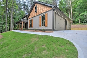 A modern two-story house with a wooden shingle roof, a covered porch, and a garage.
