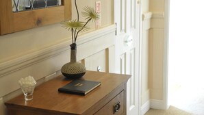 A wooden desk with a vase, a bowl of candies, and a book. - Number 46 (Hastings)