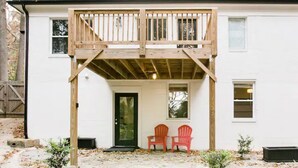 A white house with a wooden deck, two red Adirondack chairs, and a green door. - Unique & Stylish Private East Atlanta Getaway (Atlanta)