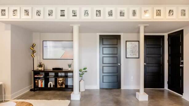 A modern interior with a central column, a black door, and a framed artwork above the door. - Unique & Stylish Private East Atlanta Getaway (Atlanta)