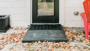 A black door with a small step leading up to it, set against a white wall with a wooden ceiling above. - Unique & Stylish Private East Atlanta Getaway (Atlanta)
