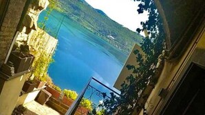 Vista a través de un arco hacia un cuerpo de agua y montañas.
