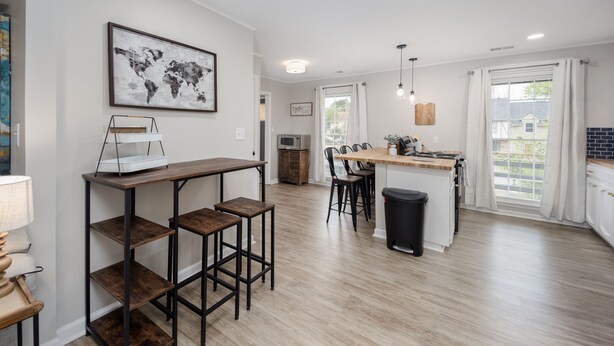 A modern kitchen with a central island, bar stools, and a world map artwork on the wall.