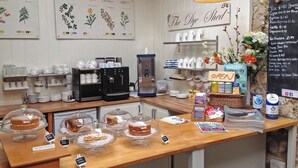Ein Café mit Holztresen, Kaffeeautomaten und einer Speisekarte.