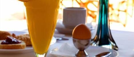 Ein Frühstück mit Orangensaft, Toast mit Marmelade und Gebäck auf einem Teller.