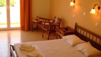 A hotel room with a bed, a desk, and two wall-mounted lamps.