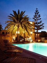 Una piscina al aire libre de temporada, sombrillas