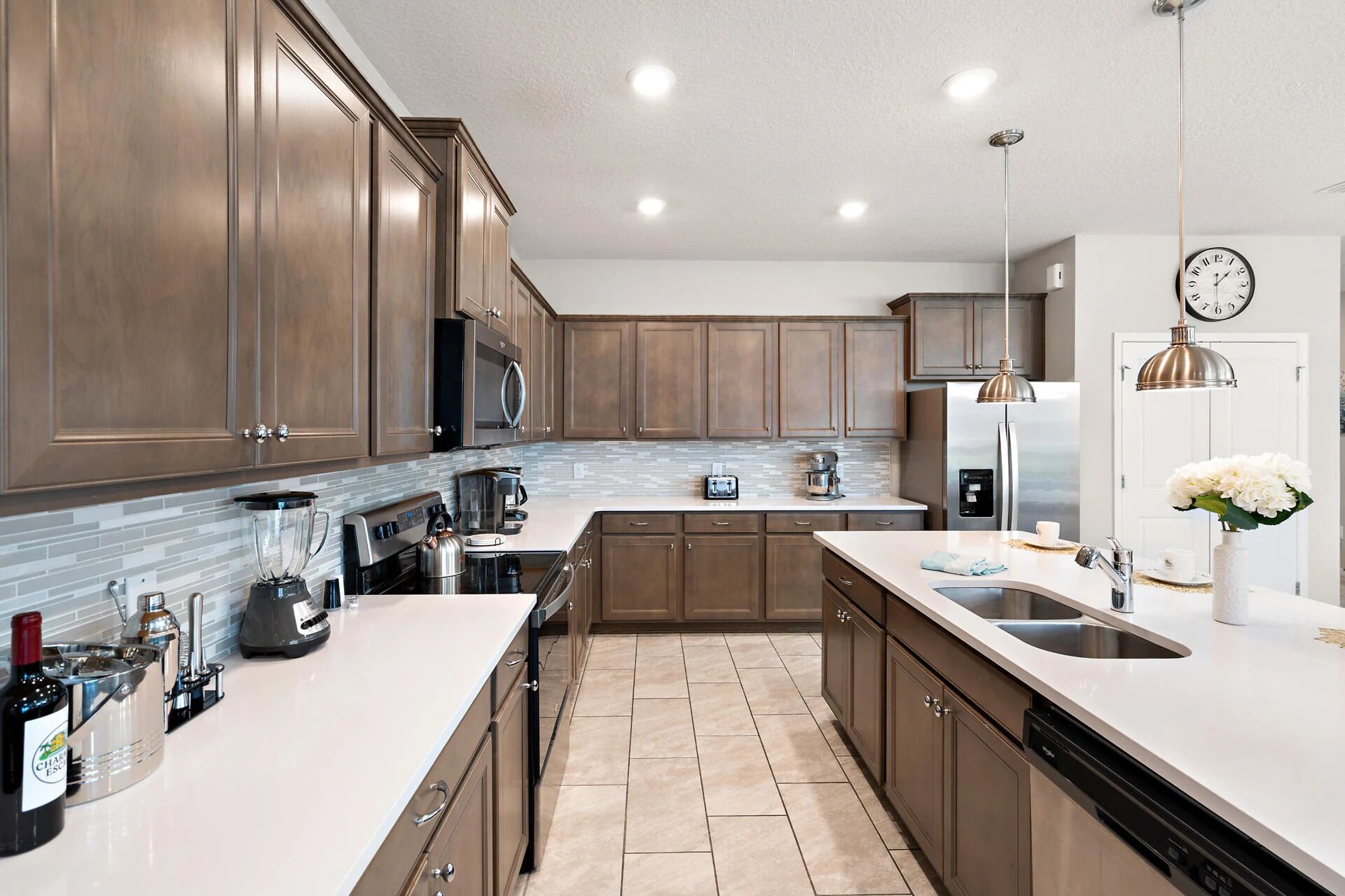 A modern kitchen with wooden cabinets, stainless steel appliances, and a tiled backsplash.