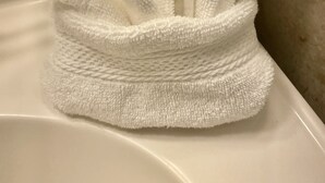 Une serviette blanche est posée sur une baignoire blanche.