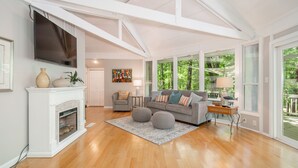 A spacious living room with a fireplace, a large window, and a cozy seating area. - Terrific home for a getaway! (Hot Springs)