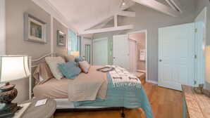 A bedroom with a bed, bedside table, lamp, and framed pictures on the wall. - Terrific home for a getaway! (Hot Springs)