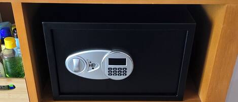 A wooden cabinet with a black safe, two drawers, and a flag on top.