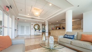A modern lobby with a glass coffee table, beige sofas, and a reception desk. - Condado Lagoon Villas/Connected Bayfront Studios w/views, kitchen/washer/dryer (San Juan)