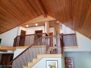 Stairs lead to a cozy upper floor with a balcony.