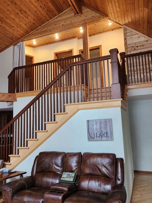 A wooden staircase with a handrail leading to an upper floor.