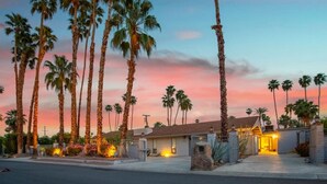 A residential area with tall palm trees and a house with a gated entrance. - Serene 1 bed Casita w/Pool, Spa & Mountain Views (Palm Springs)