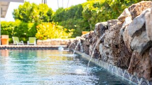 A swimming pool with a water feature cascading over rocks. - Serene 1 bed Casita w/Pool, Spa & Mountain Views (Palm Springs)