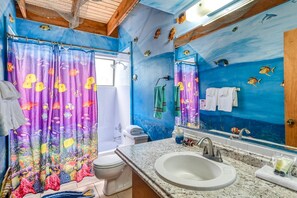A bathroom with a blue wall, a sink, and a toilet.