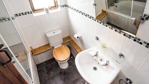 A bathroom with a toilet, sink, and mirror. - 2 bedroom accommodation in Coltishall (Coltishall)