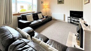 A living room with a sofa, TV stand, and a fireplace.