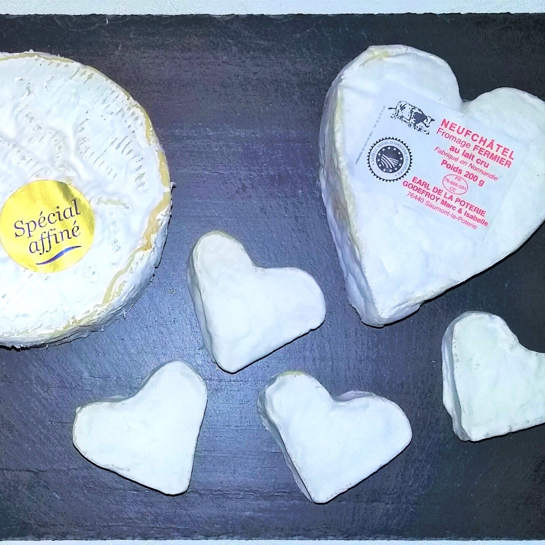 Une portion de fromage en forme de roue portant l’étiquette « Spécial affiné » et un fromage en forme de cœur avec du texte en français.