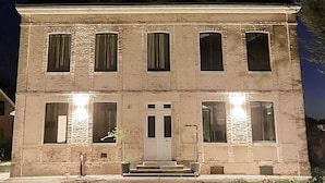 Un edificio de dos pisos con fachada simétrica, ventanas amplias y una entrada central.