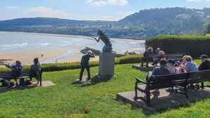 A park with benches overlooking a beach and a statue. - Y Tŷ Glas is a charming terraced cottage in New Quay. (New Quay)