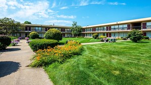 Un motel à deux étages doté d’une pelouse bien entretenue, d’un chemin et d’un petit jardin agrémenté de fleurs.