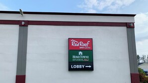 Un panneau indiquant l’emplacement de Red Roof Inn & Suites, de Home Towne Studios, ainsi que le chemin vers le hall d’accueil.