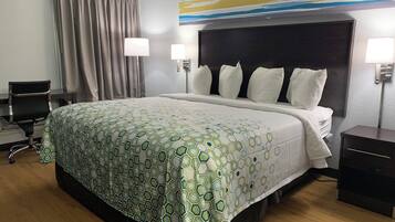Een hotelkamer met een groot bed, twee bedlampen, een bureau en een stoel.