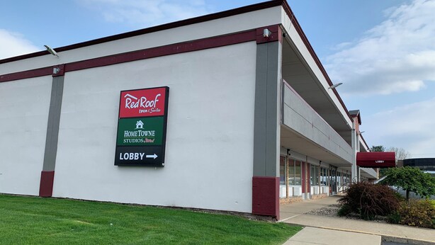 Un bâtiment de la chaîne Red Roof Inn & Suites, avec une enseigne indiquant « Home Towne Studios » et une indication pour se rendre à la réception.